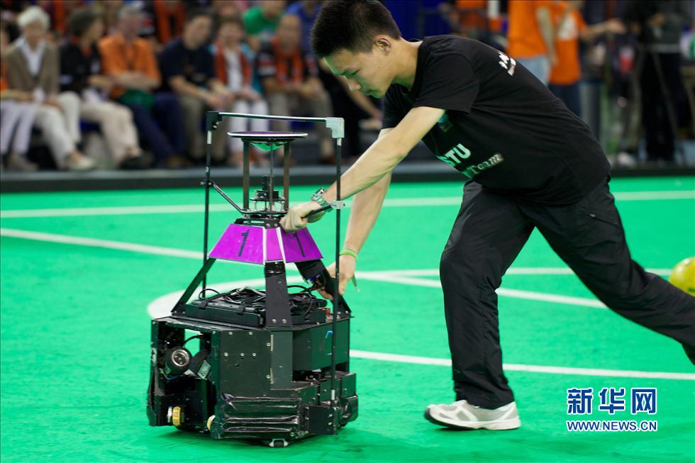 Le 30 juin à Eindhoven, aux Pays-Bas, un étudiant de l'Université des Sciences et Technologies de l'Information de Beijing procède au débogage d’un robot lors de la compétition de football pour robots RoboCup.