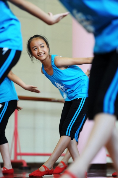 De jeunes chinoises ont reçu une formation de danse, portant toutes des ballerines rouges, lors d’un camp qui a lieu dans la ville de Yuyao, province de Zhejiang, le 2 Juillet 2013.[Photo/Xinhua]