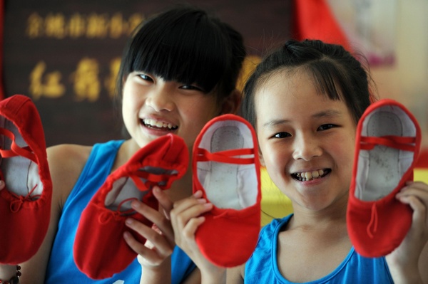 Les participantes portent toutes des chaussons rouges, lors de ce camp d'été de danse intitué «les ballerines rouges» dans la ville de Yuyao, province de Zhejiang 2 Juillet 2013. [Photo/Xinhua]