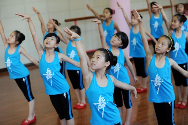 Place à la danse, avec ce camp d'été réservé aux enfants de migrants, un programme de danse de ballerines rouges, qui se déroule dans la ville de Yuyao, province de Zhejiang 2 Juillet 2013. [Photo/Xinhua]