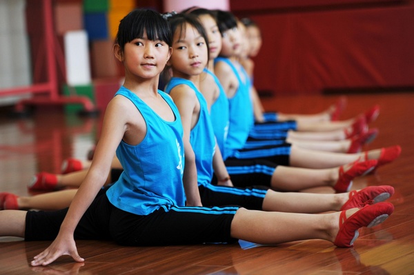 Le 2 juillet 2013, de jeunes chinoises assistent à un camp de danse, appelé « les ballerines rouges », qui a lieu dans la ville de Yuyao, la province du Zhejiang. Ce camp d'été, gratuit pour les enfants de migrants, vise à les aider à obtenir une formation en danse. Soit la participation de 22 enfants de migrants, des filles âgées entre 7 et 14 ans, venant de la province du Guizhou, d'Anhui, du Hunan et de Chongqing. Les meilleurs danseuses seront sélectionnées en tant que membres de la «Red Shoes troupe» et recevront une formation de danse plus poussée. [Photo/Xinhua]