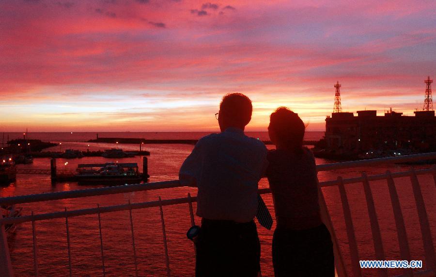 Photo prise le 3 juillet montrant des touristes venant du monde entier admirant de beaux paysages du coucher du soleil dans le district de Tamsui à Taiwan.