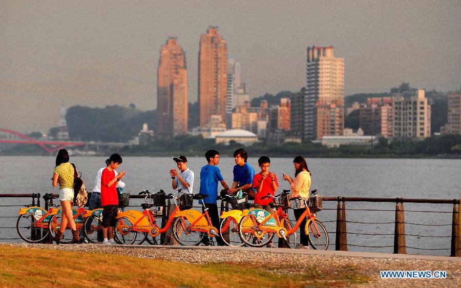 Photo prise le 3 juillet montrant des touristes venant du monde entier admirant de beaux paysages du coucher du soleil dans le district de Tamsui à Taiwan.