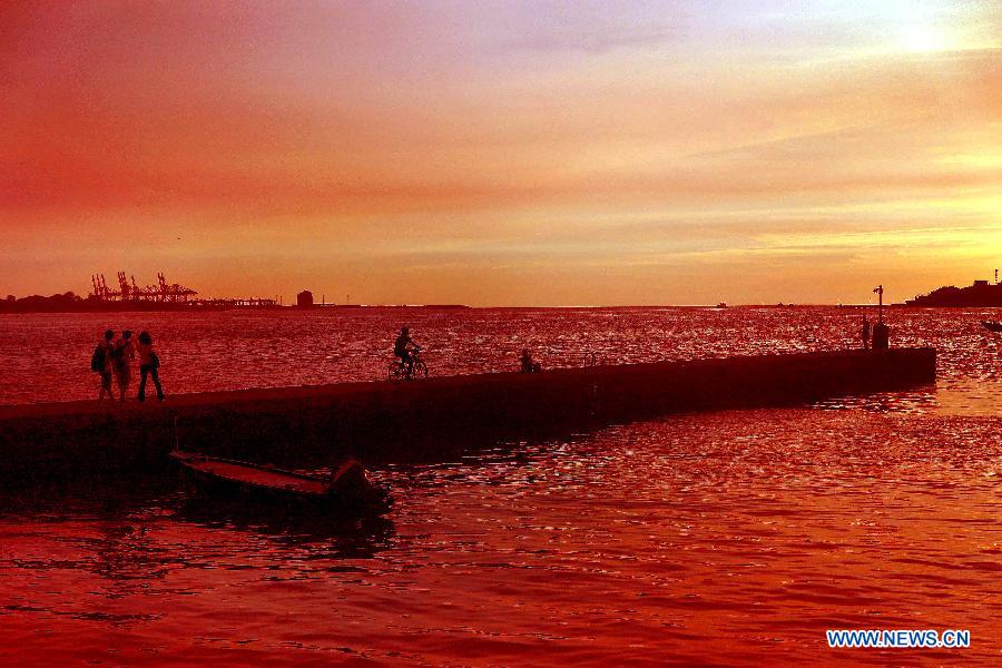 Photo prise le 3 juillet montrant des touristes venant du monde entier admirant de beaux paysages du coucher du soleil dans le district de Tamsui à Taiwan.