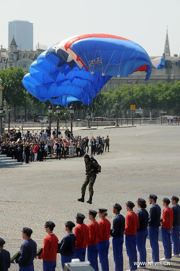 Un parachutiste se pose devant les jeunes volontaires faisant leur service civique.