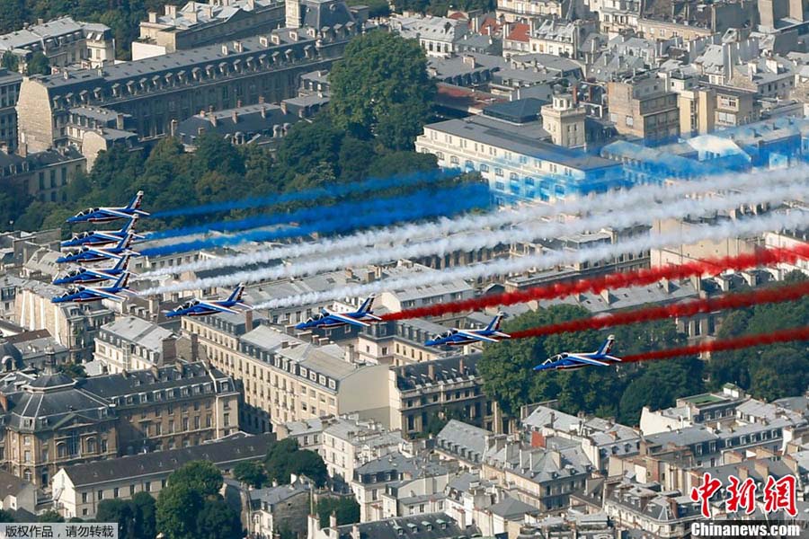 Les avions de la Patrouille de France passent au dessus des toits de Paris.