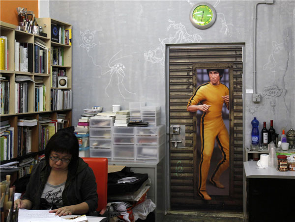 Le 18 juillet 2013 à Hong Kong, une femme visite une galerie qui presente les peintures de Bruce Lee créées par des artistes locaux. [Photo : Agences]