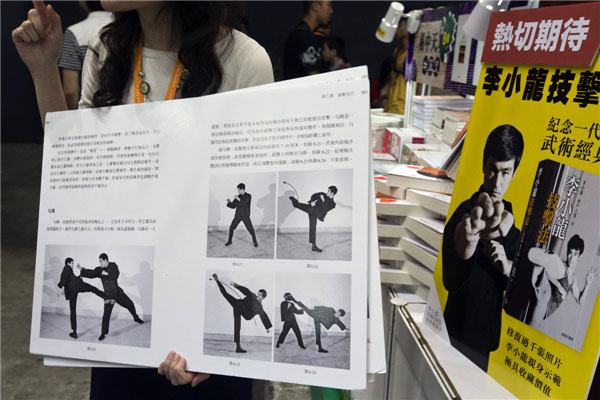 Le 17 juillet 2013 lors de la première journée de la Foire du livre à Hong Kong, une libraire a présenté la version chinoise la plus récente du livre 'Bruce Lee's Fighting Method' écrit par Bruce Lee en personne. [Photo : Agences]
