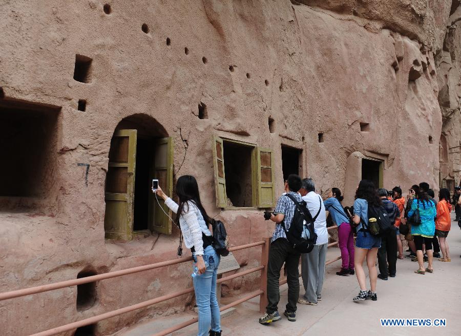 Le 17 juillet 2013, des touristes visitent les grottes du temple Bingling dans le district de Yongjing, la province du Gansu en Chine. [Photo: Xinhua]