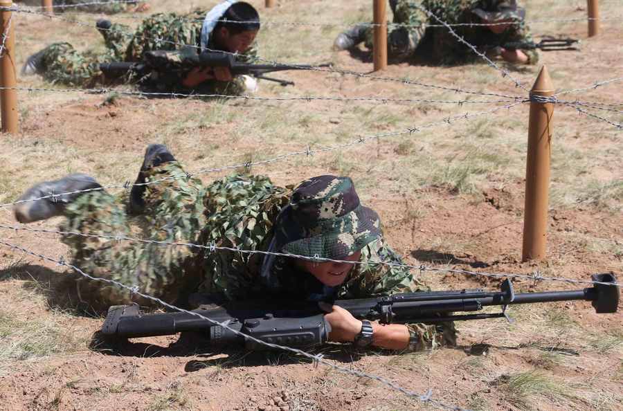 Des membres des forces spéciales de l'Armée Populaire de Libération chinoise (APL) participent à un concours militaire général sur une base d'entraînement de l'APL, dans la région autonome de Mongolie intérieure, en Chine du Nord, le 23 juillet 2013. [Photo / Xinhua] 