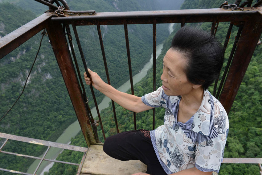 Le 23 juillet, une femme emprunte le téléphérique pour regagner le village de Yushan situé dans les montagnes du district de Hefeng dans la province chinoise du Hubei. 