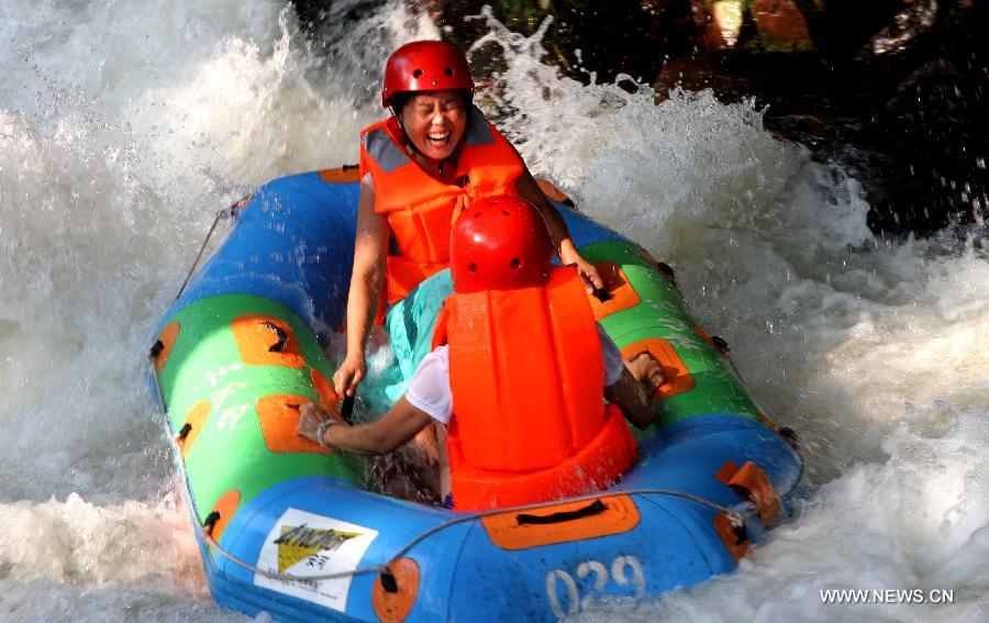 Des touristes font du rafting dans un parc forestier dans le dictrict de Jing'an de la province du Jiangxi (est de la Chine), le 28 juillet 2013. Une vague de chaleur a frappé de nombreuses régions de la Chine ces derniers jours.