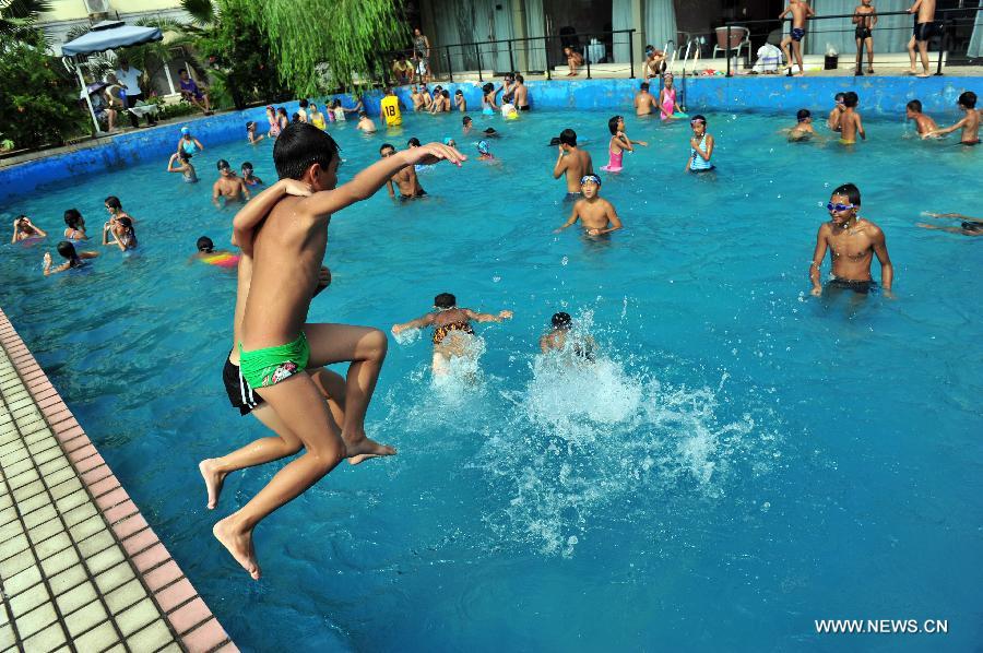 Des élèves sautent dans une piscine dans le district de Zigui de la province du Hubei (centre de la Chine), le 28 juillet 2013. Une vague de chaleur a frappé de nombreuses régions de la Chine ces derniers jours.