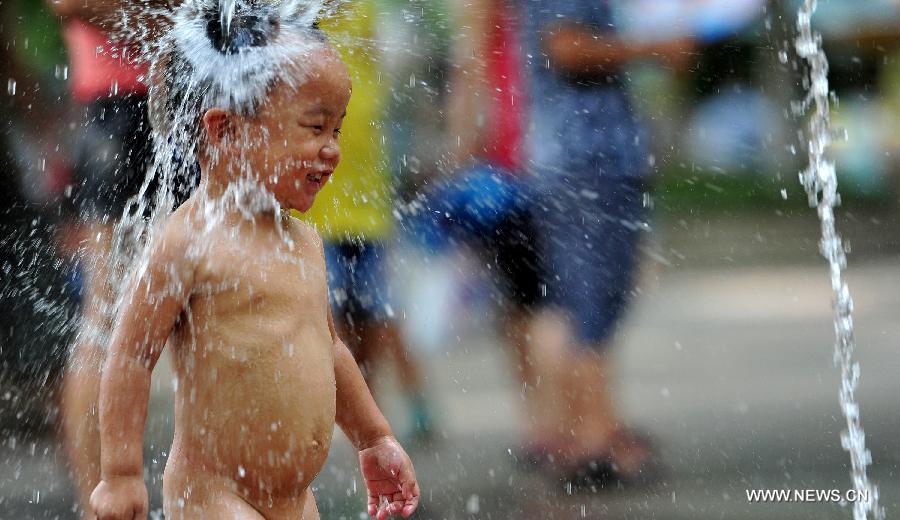 Un enfant se rafraîchit dans une fontaine à Hangzhou, capitale de la province du Zhejiang (est de la Chine), le 28 juillet 2013. Une vague de chaleur a frappé de nombreuses régions de la Chine ces derniers jours.