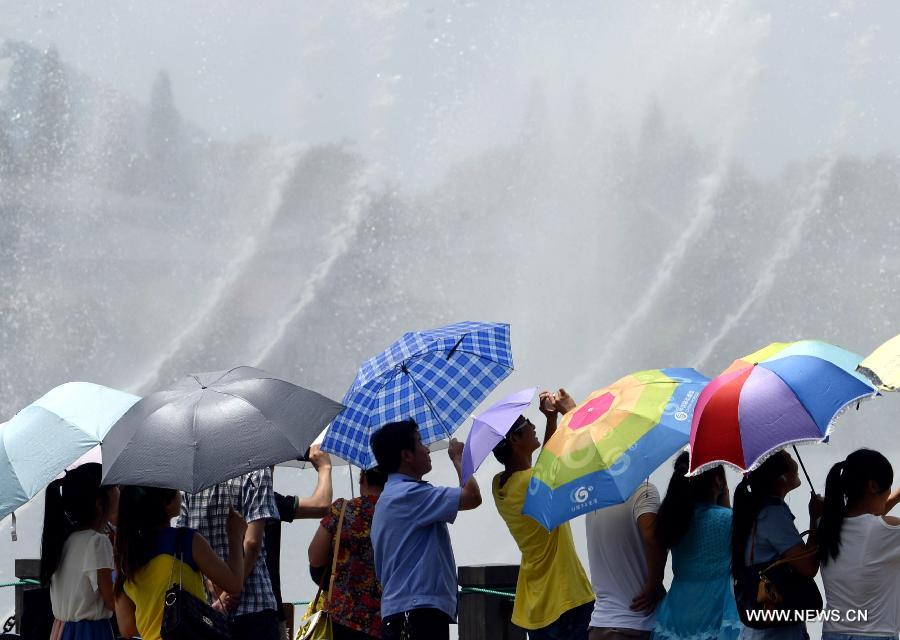 Des gens se rafraîchissent près d'une fontaine musicale à Hangzhou, capitale de la province du Zhejiang (est de la Chine), le 28 juillet 2013. Une vague de chaleur a frappé de nombreuses régions de la Chine ces derniers jours.