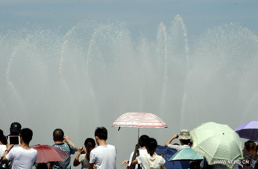 Des gens se rafraîchissent près d'une fontaine musicale à Hangzhou, capitale de la province du Zhejiang (est de la Chin