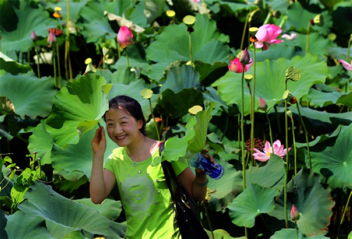 Une femme pose pour une photo, lors de la première édition du Festival des Lotus, à Wufu, dans la ville de Wuyishan, dans la Province du Fujian, en Chine de l'Est, le 26 juillet 2013. Le festival durera jusqu'au 1er octobre. [Photo Zouhong / Asianewsphoto]