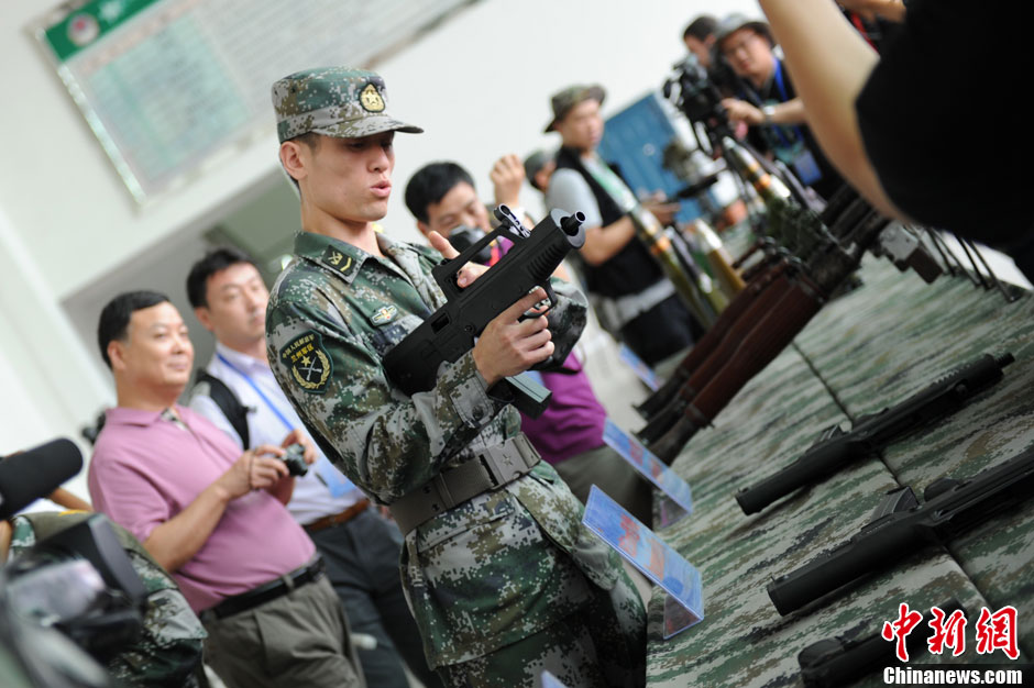 Un soldat de l'APL montre un pistolet-mitrailleur aux journalistes.