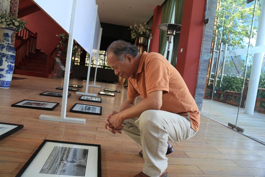 Juan I-Jong, un photographe très populaire venant de Taïwan, prépare ses oeuvres pour l'ouverture de la cinquième Exposition internationale de photographie de Dali. (Photo : Xinhua/Wen Juan)