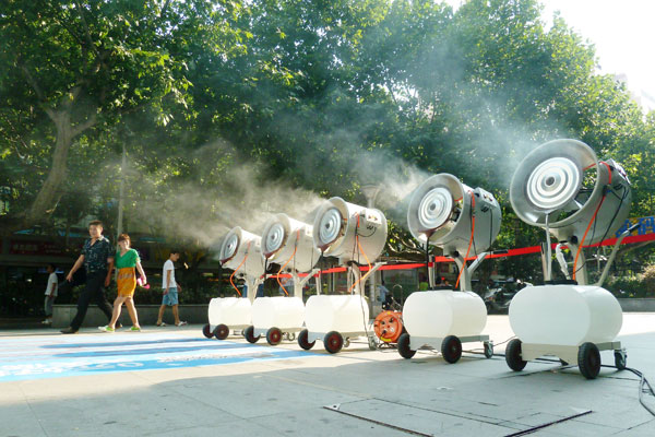 Face à la canicule, cinq ventilateurs de refroidissement ont été placés devant un magasin de Nanjing pour rafraîchir les passants, dans la province chinoise du Jiangsu à l'est du pays, le 29 juillet 2013.