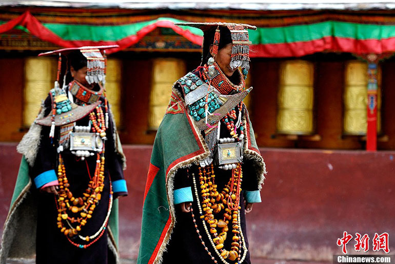 Le 8 juillet 2013, dans le village de Kagayi du district de Burang situé dans la préfecture Nagari de la région autonome du Tibet en Chine, deux femmes portent le costume traditionnel tibétain – le costume du paon. (Photo : Chinanews /Li Lin)