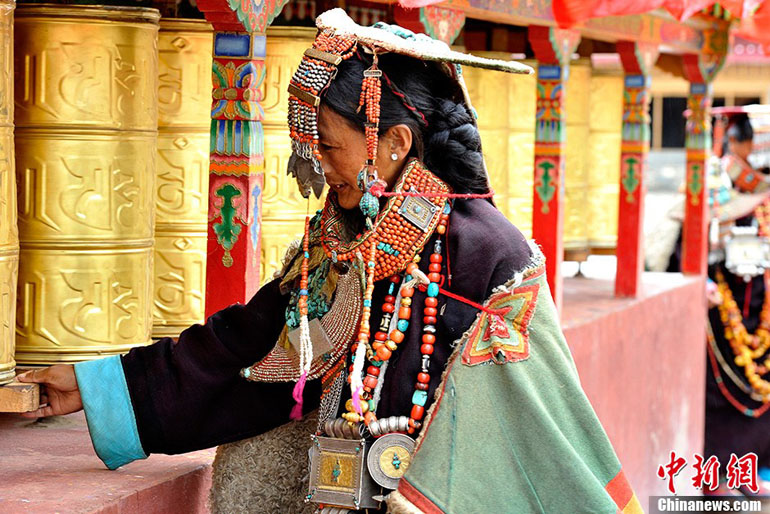 Le 8 juillet 2013, dans le village de Kagayi du district de Burang situé dans la préfecture Nagari de la région autonome du Tibet en Chine, une femme porte le costume traditionnel tibétain – le costume du paon. (Photo : Chinanews /Li Lin)
