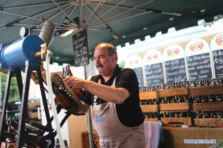 Un vendeur prépare de la bière lors du 17e Festival de la Bière de Berlin, sur l'Avenue Karl Marx à Berlin, en Allemagne, le 4 août 2013. Quelque 330 brasseries venant de 86 pays et régions sont venues à Berlin pour ce Festival international de la Bière qui débute depuis vendredi et durera trois jours. (Xinhua/Zhang Fan)