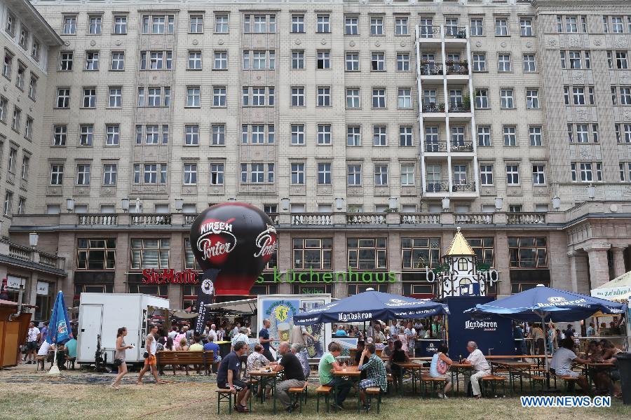 Des touristes lors du 17e Festival de la Bière de Berlin, sur l'Avenue Karl Marx à Berlin, en Allemagne, le 4 août 2013. Quelque 330 brasseries venant de 86 pays et régions sont venues à Berlin pour ce Festival international de la Bière qui débute depuis vendredi et durera trois jours. (Xinhua/Zhang Fan) 