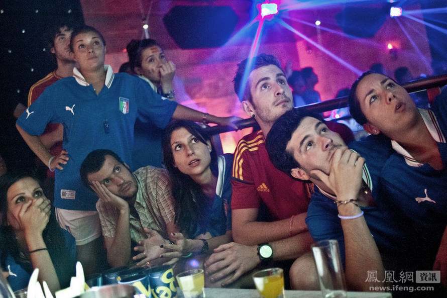 Dans un bar, des étudiants italiens et espagnols regardent ensemble un match de foot de l'Euro 2012 entre leurs deux pays.