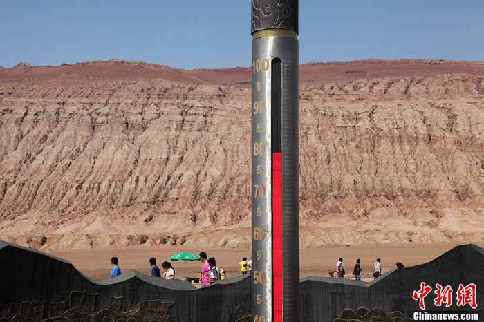 Le 30 juillet, un thermomètre cylindrique géant indique que la température de la surface de la terre atteint 78°C dans les Monts flamboyants de Tourfan, dans la région autonome ouïgoure du Xinjiang.