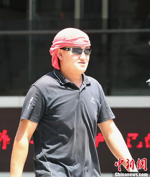 Le 5 août, un homme avec une serviette sur la tête à Jifangbei, à Chongqing.