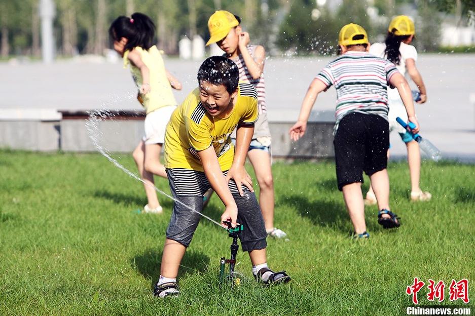 Le 4 août vers le soir, à Taiyuan, dans le Shanxi, des enfants s'amusent avec de l'eau.