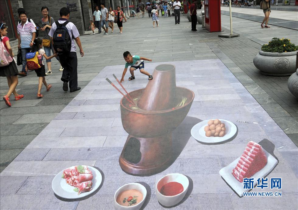 Un enfant s'amuse avec cette grande peinture en 3D à même le sol.