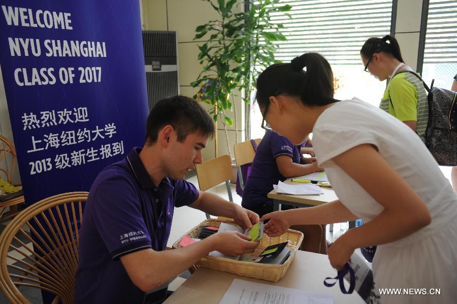 Le 11 août 2013, une étudiante de l'Université New York-Shanghai prend sa carte de chambre auprès d'un employé. (Photo : Xinhua/Liu Xiaojing)