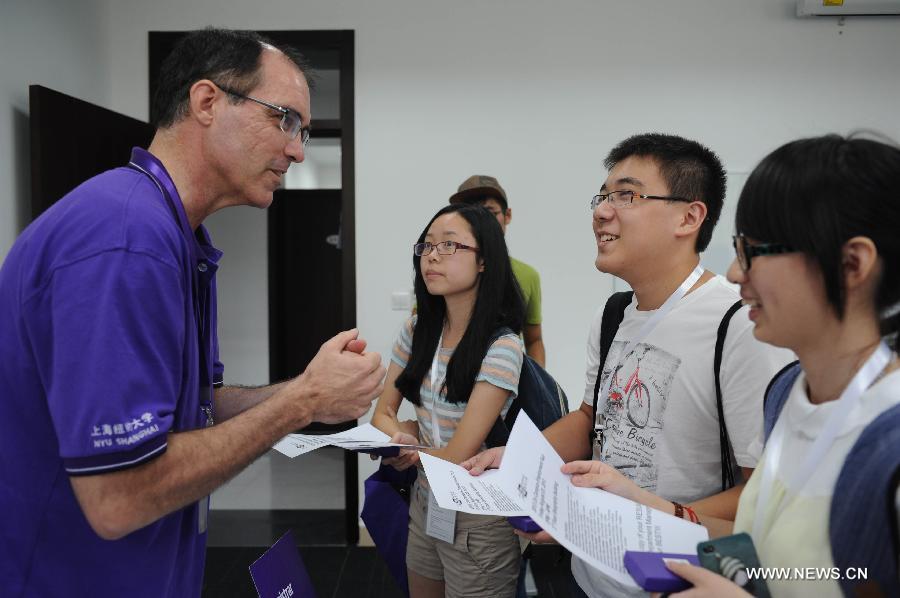 Le 11 août 2013 dans la salle d'inscription de l'Université New York-Shanghai, un employé communique avec plusieurs étudiants chinois. (Photo : Xinhua/Liu Xiaojing)