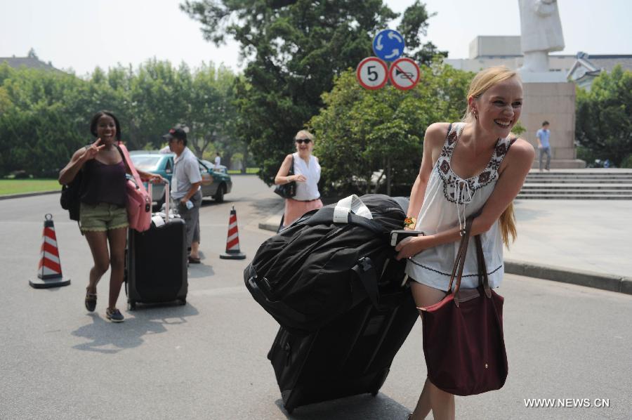 Le 11 août 2013, plusieurs étudiants étrangers de l'Université New York-Shanghai marchent avec leurs valises sur le campus de l'Université normale de l'Est de Chine. (Photo : Xinhua/Liu Xiaojing)