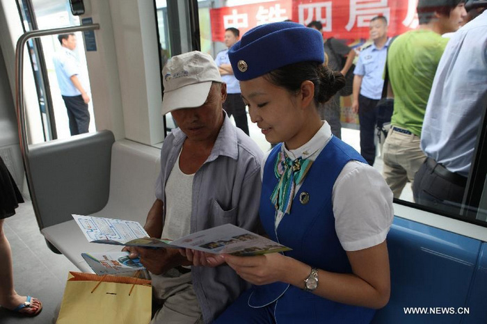 Un agent donne les premières informations à un usager, concernant le réseau de tramway, dans le nouveau district de Hunnan à Shenyang (la capitale de la province du Liaoning, au nord de la Chine), le 15 août 2013.