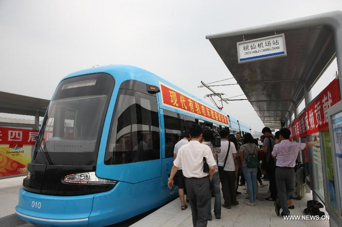 Des usagers montent à bord d'un tram, dans le nouveau district de Hunnan à Shenyang (la capitale de la province chinoise du Liaoning, au nord du pays), le 15 août 2013.