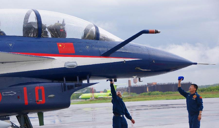 Des membres du personnel procèdent à la maintenance d'un chasseur J-10 de l'armée de l'air de l'Armée Populaire de Libération (APL) chinoise dans un aéroport russe, pour son premier meeting aérien à l'étranger, le 20 août 2013.