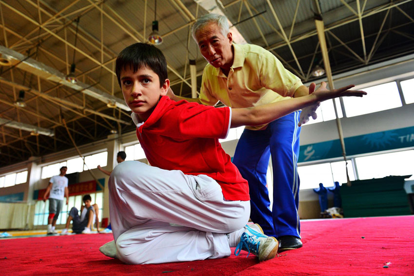 Yuan Xi, maître chinois de kung-fu, guide Christopher, un étudiant de 13 ans originaire d'Allemagne, dans la pratique de mouvements d'arts martiaux à Tianjin, en Chine du Nord, le 21 août 2013. [Photo / Xinhua]