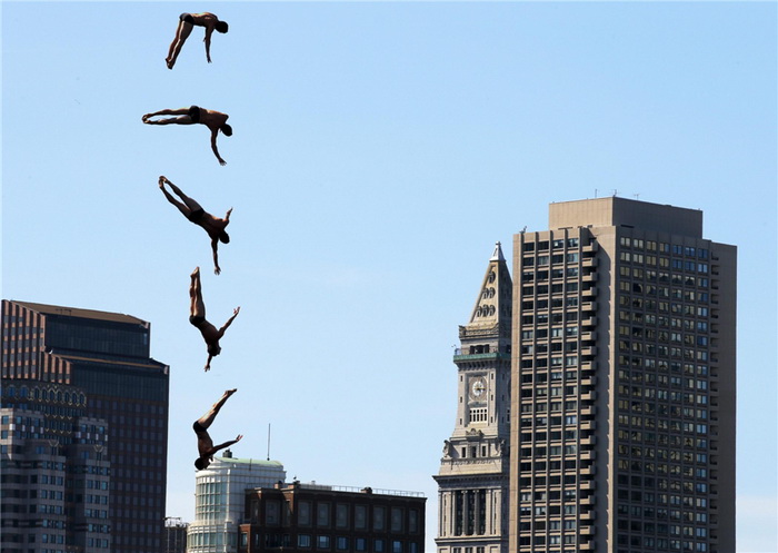 L'Américain Steven LoBue plonge depuis le toit de l'Institut d'Art Contemporain lors de la compétition Bull Cliff Diving Red World Series 2013 à Boston, dans le Massachusetts, le 25 août 2013. Les plongeurs ont sauté d'une hauteur de près de 30 mètres depuis le toit du musée d'art contemporain, dans le port de Boston. Il s'agit d'une photographie à expositions multiples.