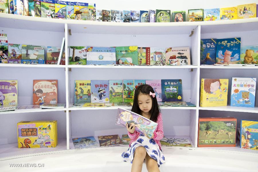 Mercredi 28 août, lors de la 20e Foire internationale du livre de Beijing, une petite fille lit dans la section réservée aux livres pour les enfants. (Photo : Xinhua / Zhaobing)