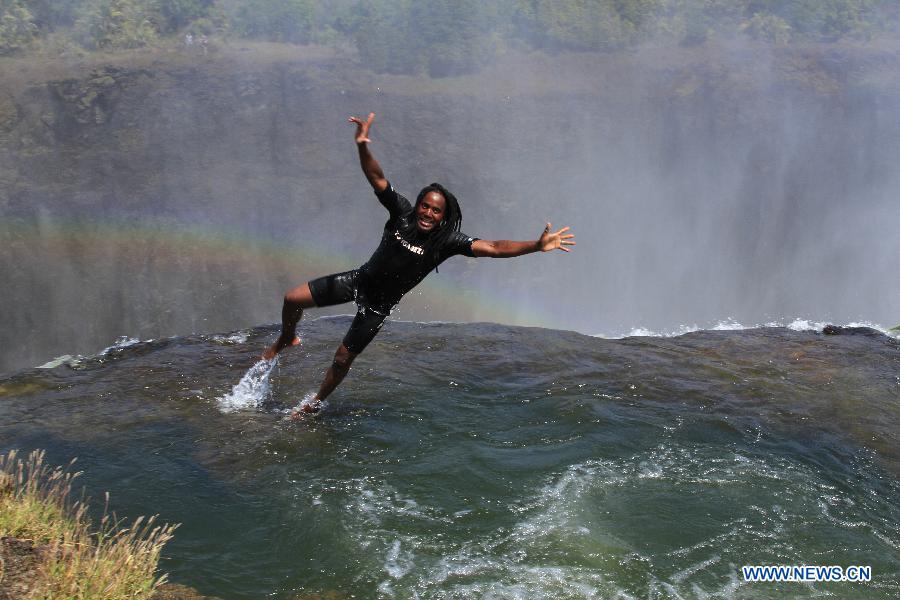Un guide local montre comment sauter dans la piscine du diable en haut des chutes Victoria, à la frontière du Zimbabwe et de la Zambie, le 28 août 2013.
