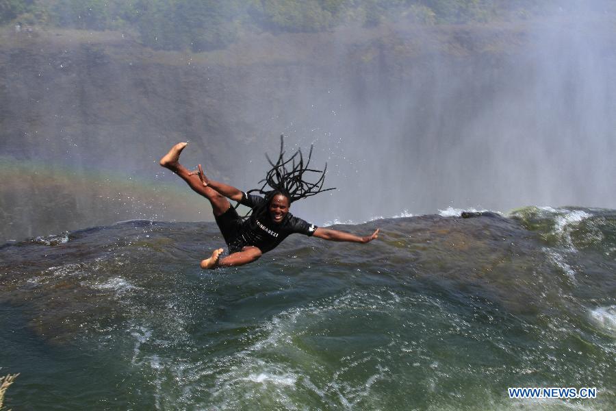 Un guide local montre comment sauter dans la piscine du diable en haut des chutes Victoria, à la frontière du Zimbabwe et de la Zambie, le 28 août 2013.