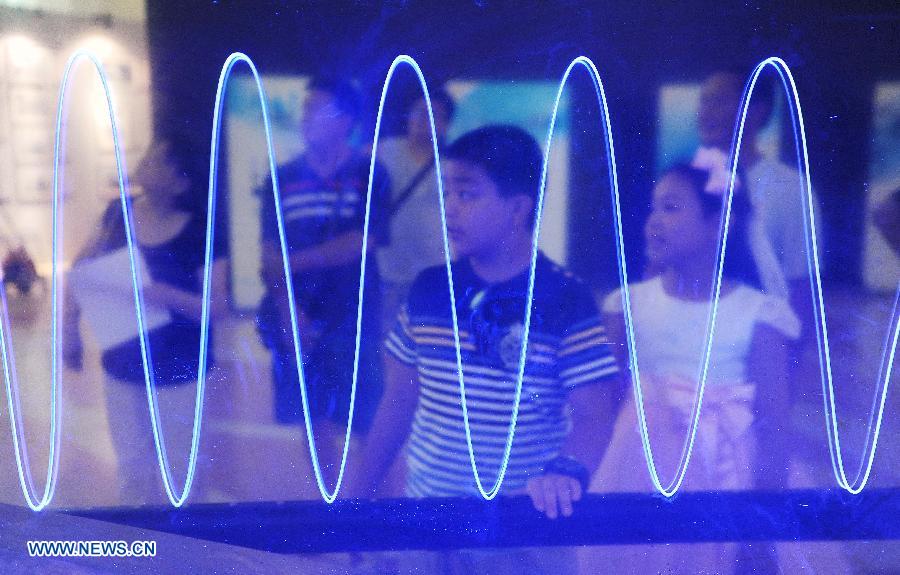 Un jeune Chinois face à un simulateur, à l'occasion de l'édition 2013 de l'Exposition internationale «Science et Art» de Shanghai, en Chine orientale, le 28 août 2013.