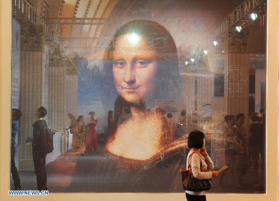 Des visiteurs devant une œuvre d'art créatif "Mona Lisa Smile", de l'édition 2013 de l'Exposition internationale «Science et Art» de Shanghai, en Chine orientale, 28 août 2013.