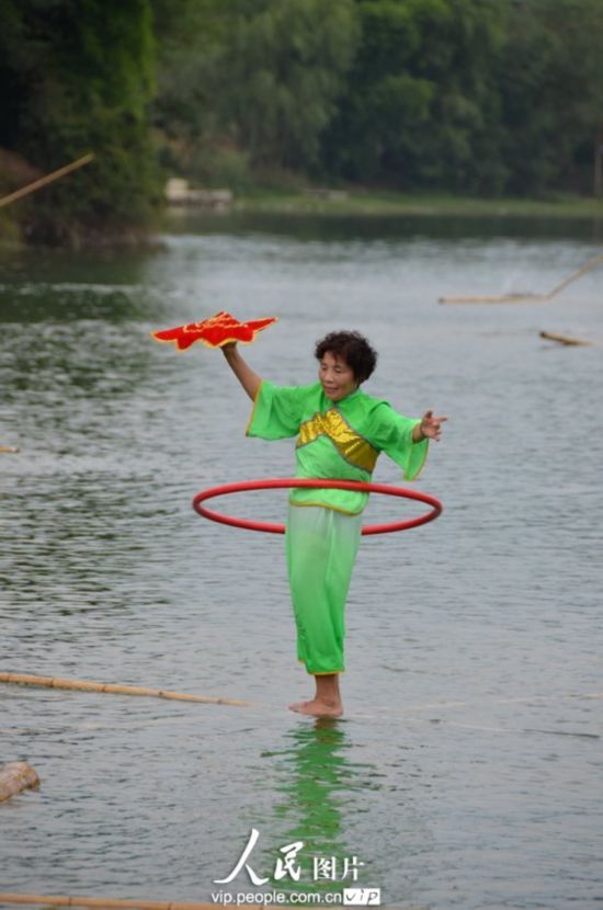Le 23 aôut 2013, une acrobate pratique le rafting sur une tige de bambou sur le fleuve Meijiang dans le district de Meitan dans la province chinoise du Guizhou. 
