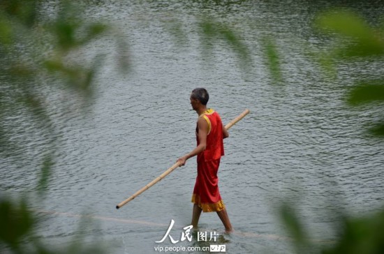 Le 23 aôut 2013, un acrobate pratique le rafting sur une tige de bambou sur le fleuve Meijiang dans le district de Meitan dans la province chinoise du Guizhou. 