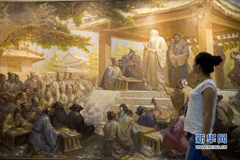 Jeudi 29 août; lors de la 16e Exposition internationale d'Art de Beijing, une visiteuse regarde une peinture qui met en lumière l'image d'un cours donné par Confucius à ses disciples. (Photo : Xinhua)
