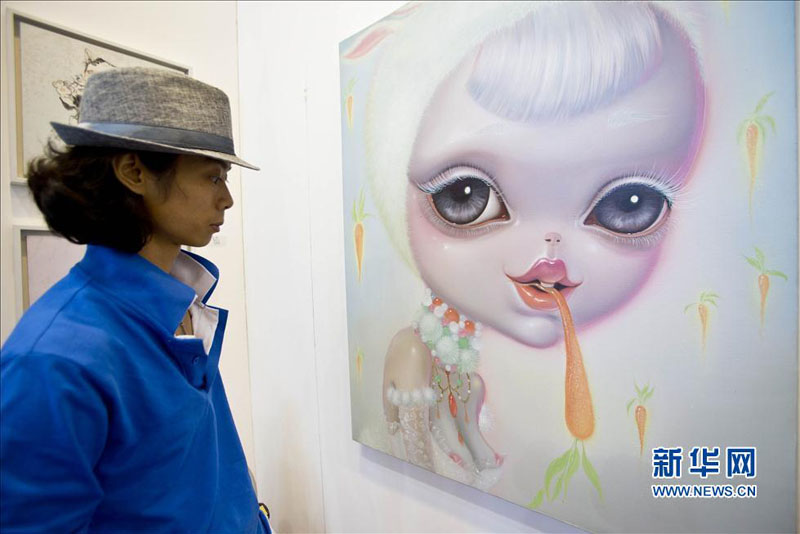 Jeudi 29 août, une visiteuse contemple un tableau présenté lors de la 16e Exposition internationale d'Art de Beijing. (Photo : Xinhua)